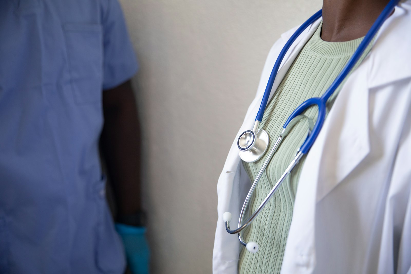 Médico examinando paciente, representando a perícia que comprova o nexo causal da doença ocupacional para fins de estabilidade