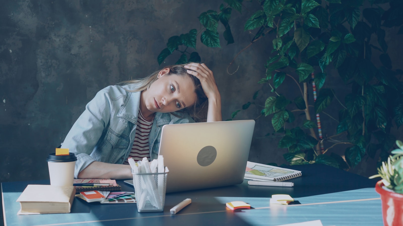 Profissional exausta diante do computador representando doença ocupacional por transtorno mental no trabalho