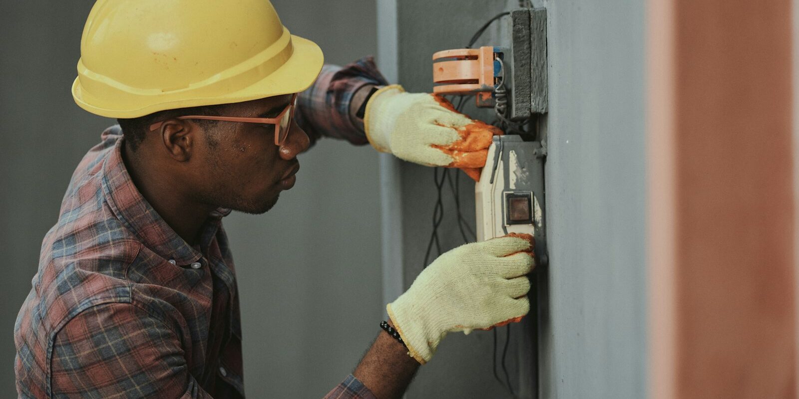 Eletricista instalando fiação com capacete — adicional de periculosidade: quem tem direito