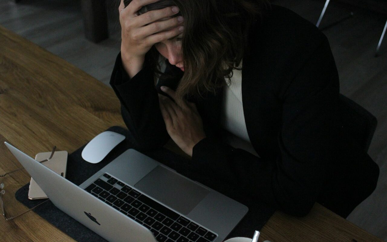 Trabalhadora abalada por assédio moral no trabalho em frente ao computador