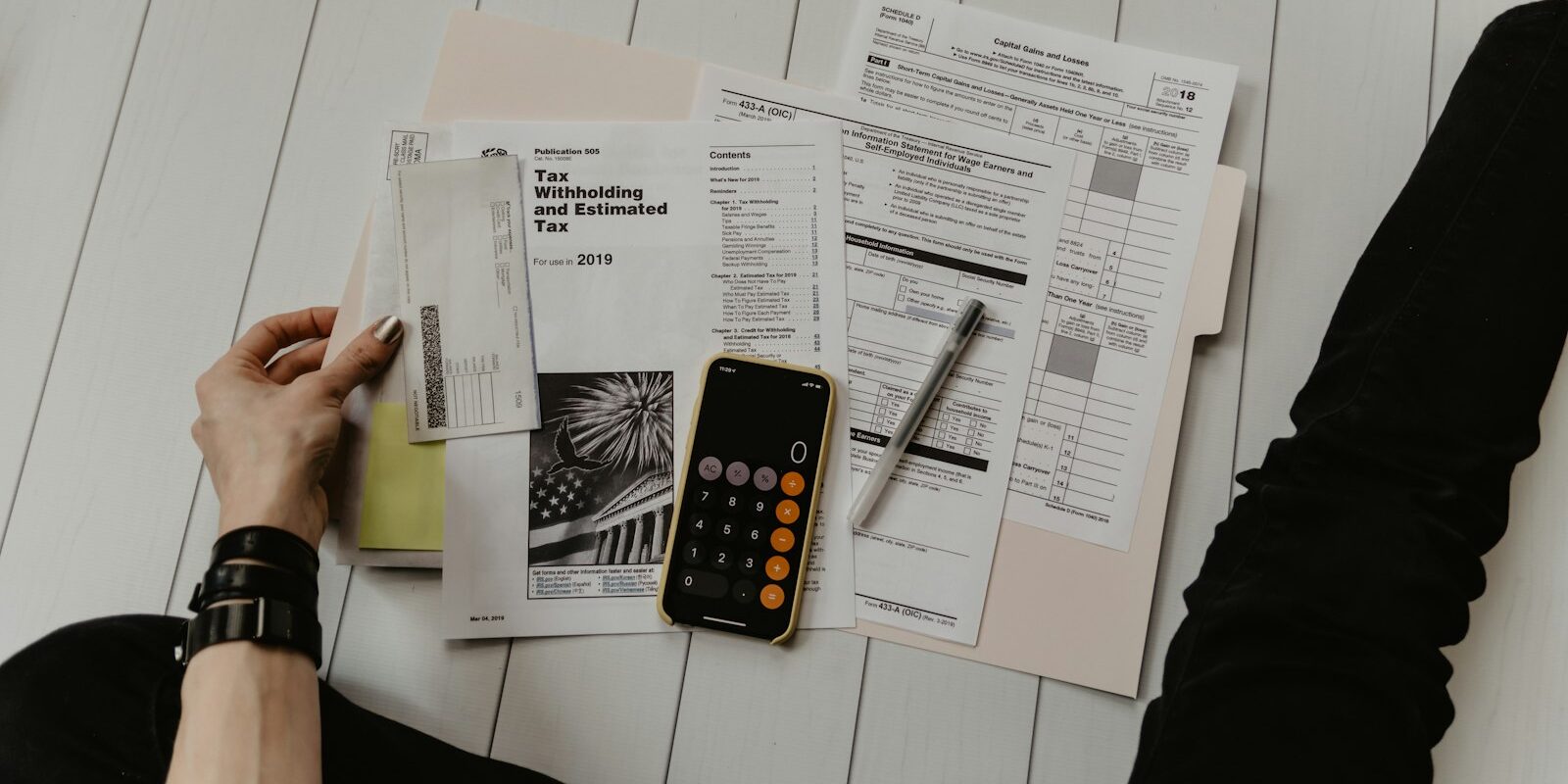 Pessoa com papel e calculadora mostrando como calcular o 13º salário em 2026