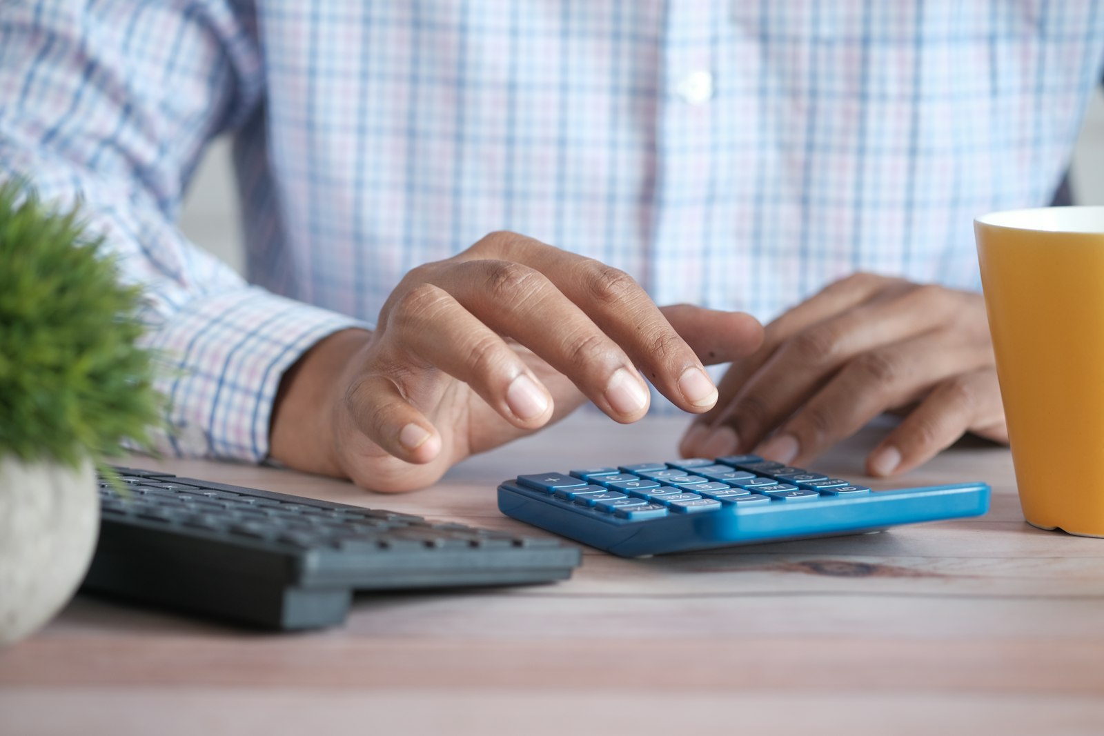 Trabalhador usando calculadora para entender como calcular o 13º salário proporcional